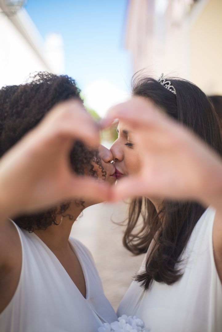 Portrait of just married women making heart sign